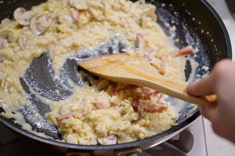 4.3に溶き卵を加えて手早くしっかりと混ぜたら皿に盛り、粗びき黒こしょうをトッピングする。